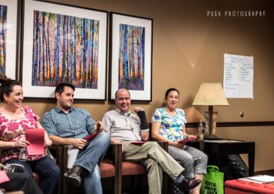 Couples in a birth class in Lehi, UT laughing and having a discussion in class.